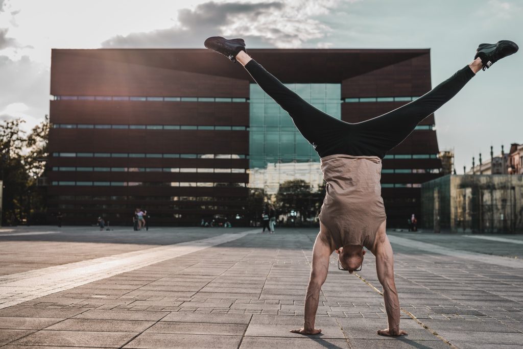 A person doing a handstand in front of a building
