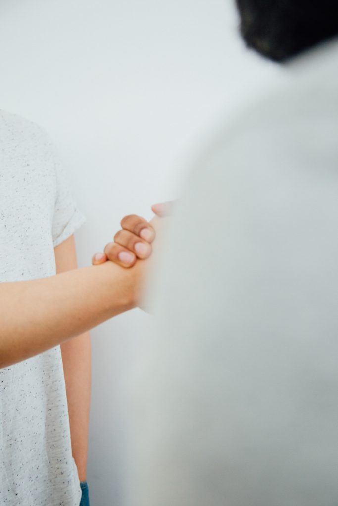 two people holding hands in a hand shake gesture