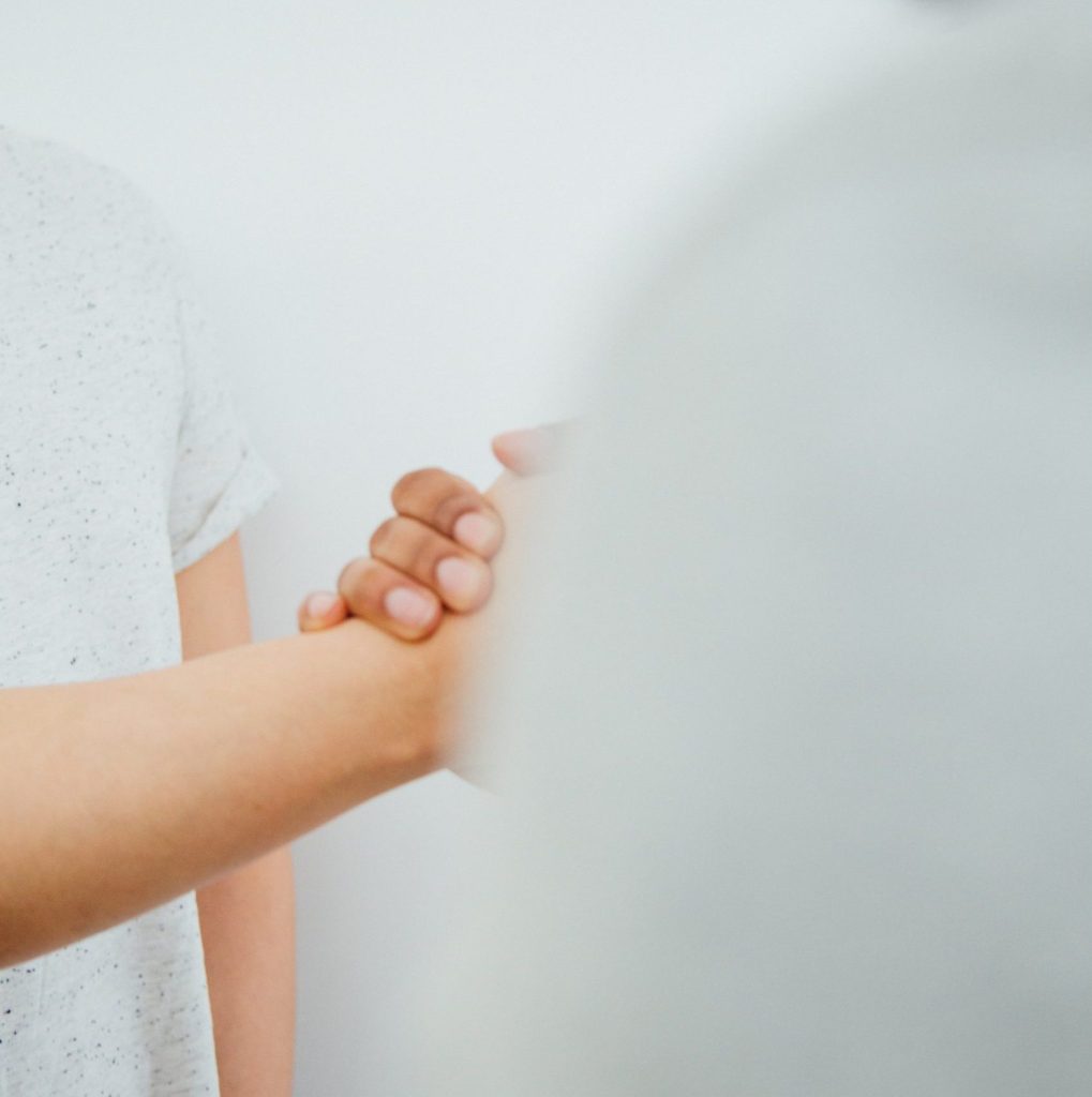 two people holding hands in a hand shake gesture