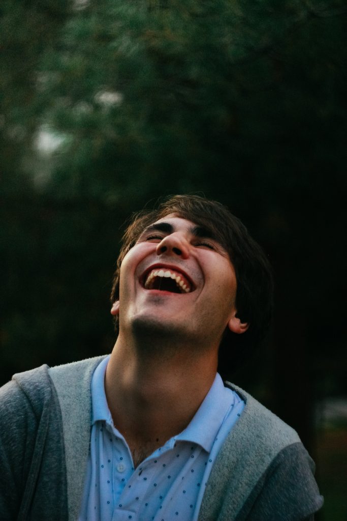 A male leaning his head back while laughing