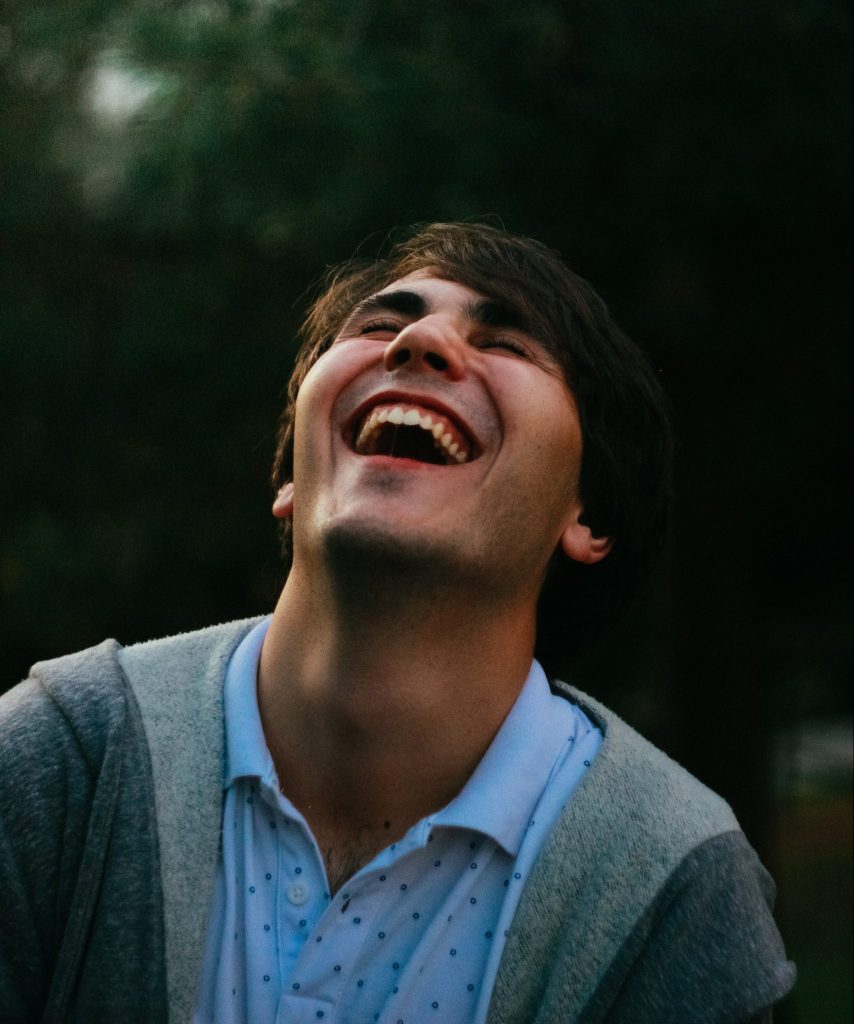 A male leaning his head back while laughing