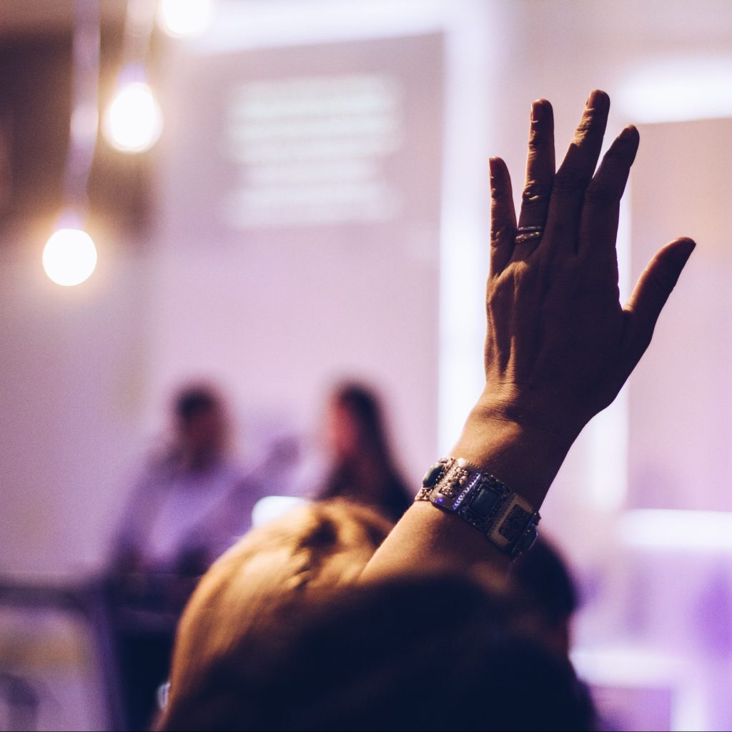 a photograph of someone's hand in the air at an event