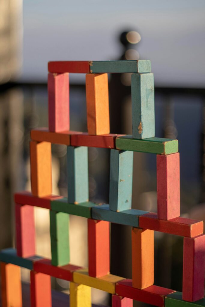 A tower created with different coloured wooden building blocks